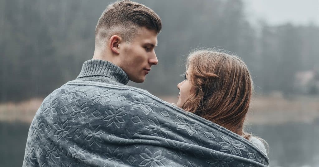 Couple sharing a blanket outside